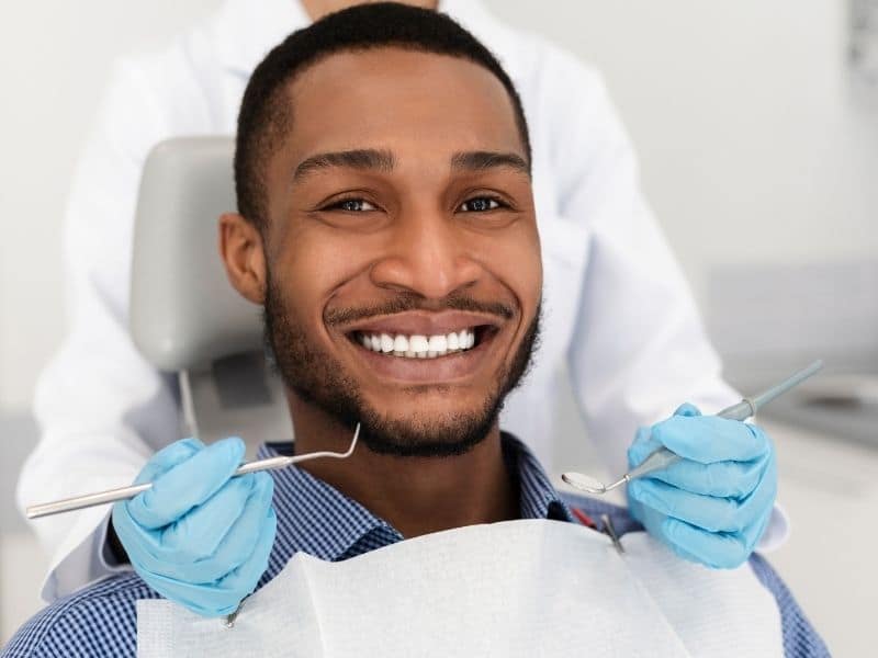 Smiling patient after cosmetic smile makeover at DPI Dental Howard Beach
